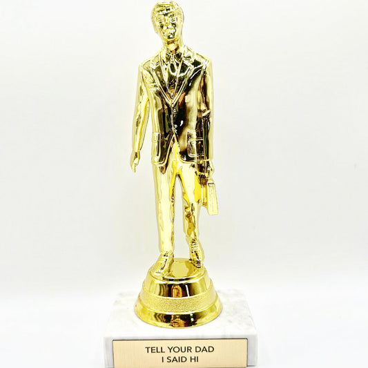 A trophy with a golden figure standing on a marble base. The plaque on the base reads 'TELL YOUR DAD I SAID HI'.
