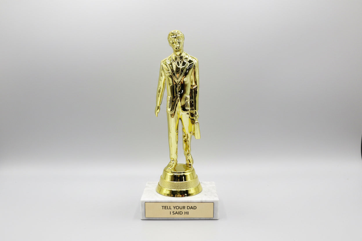 A trophy with a golden figure standing on a marble base. The plaque on the base reads 'TELL YOUR DAD I SAID HI'.